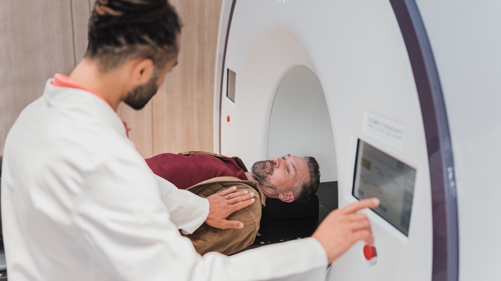 A doctor positioning a patient at a scanner