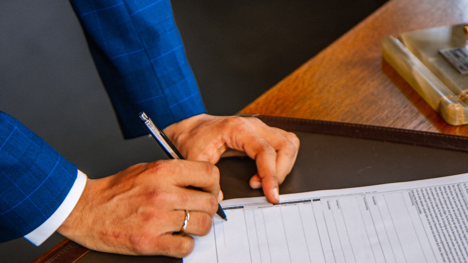 A hand completing an application form with a pen