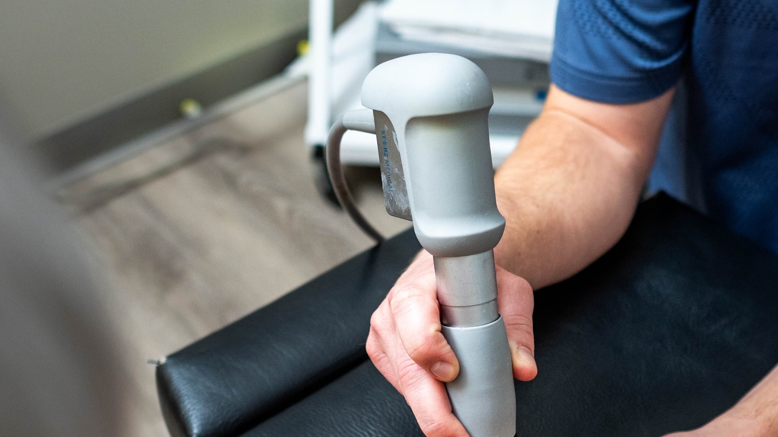 A therapist treating an arm with an ultrasound device