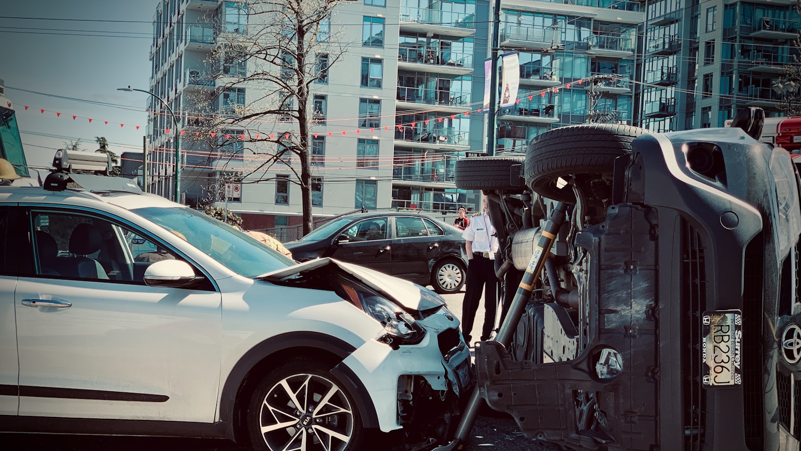 Two cars after a collision, one on its side in the road