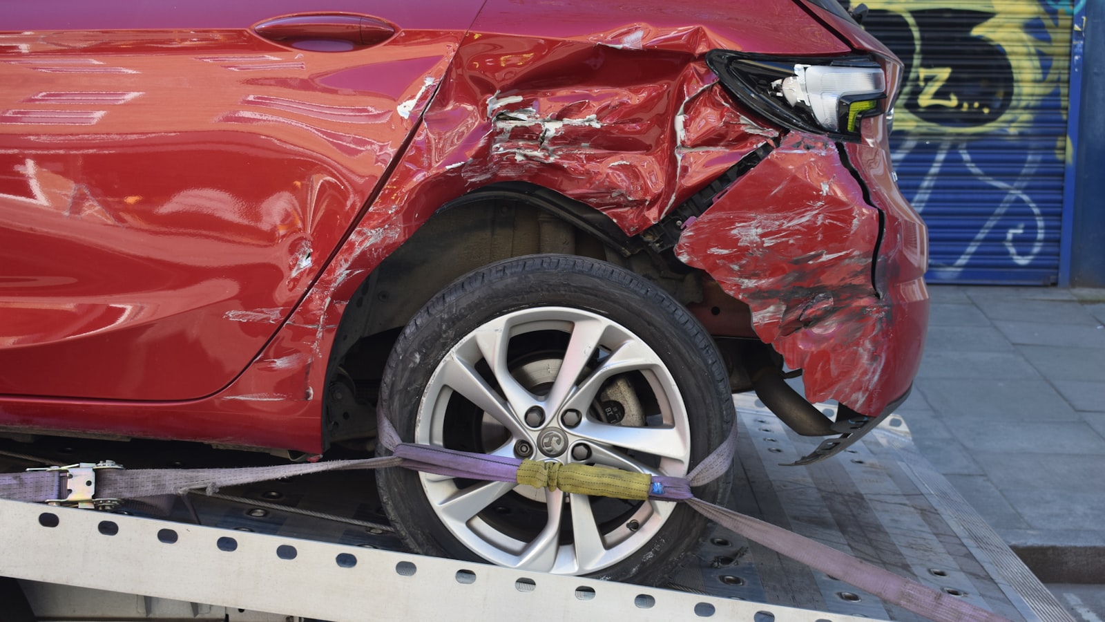A damaged car loaded on a flatbed tow truck