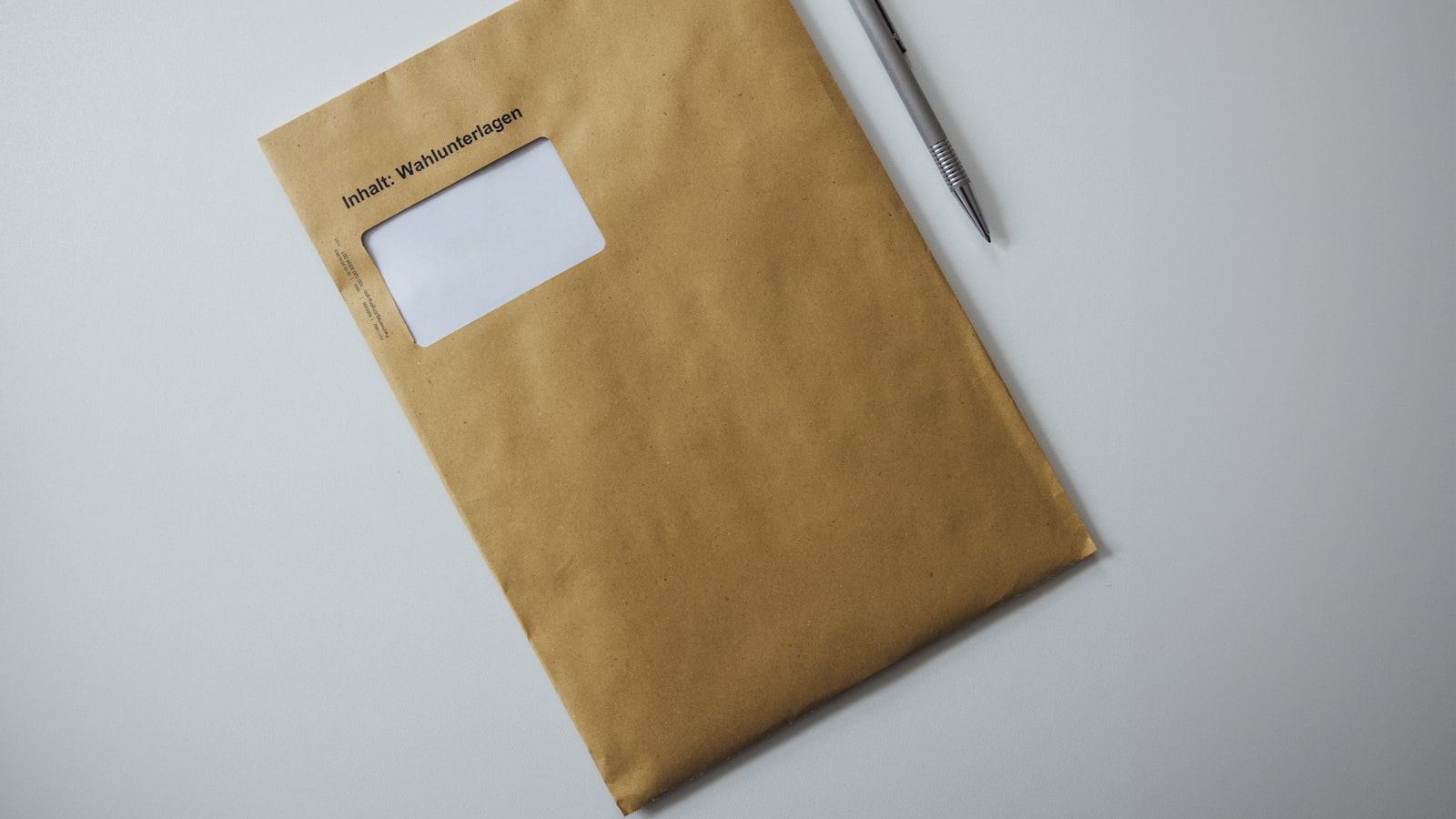 A window envelope lying unopened on a desk