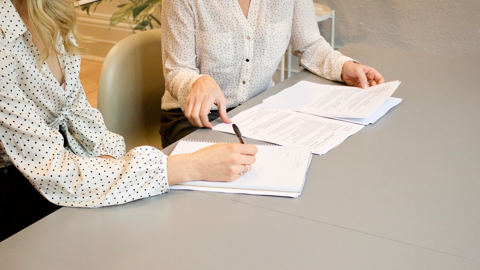 Two people reviewing paperwork together at a desk