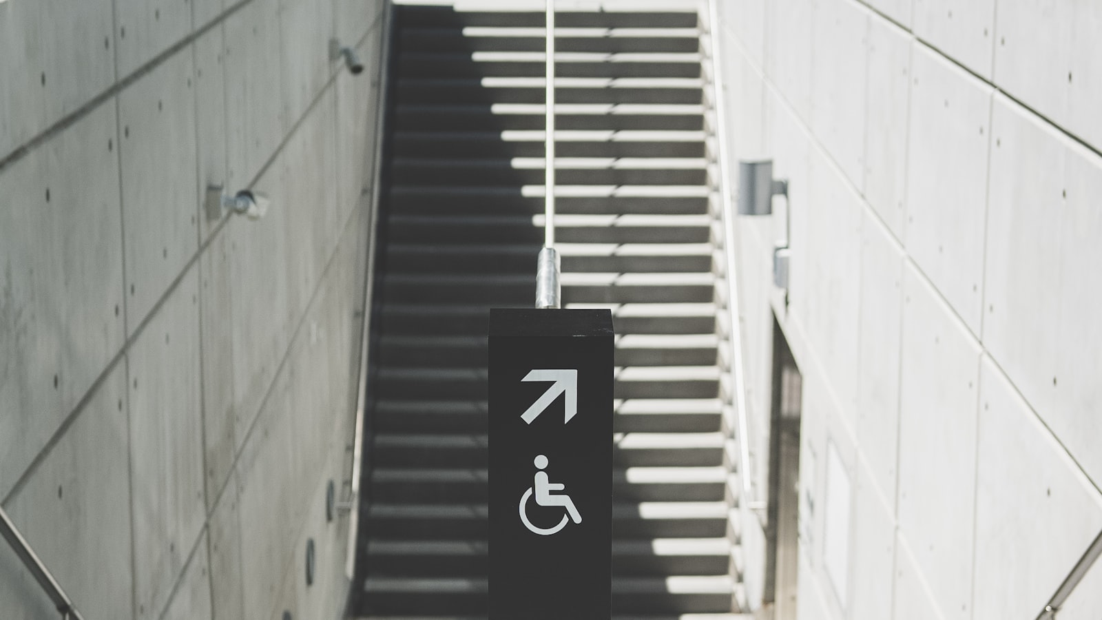 A wheelchair access sign beside a flight of stairs
